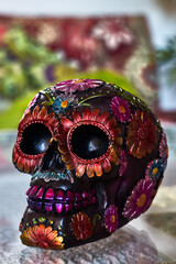 Mexican day of the dead skull with multicolored daisies and purple teeth