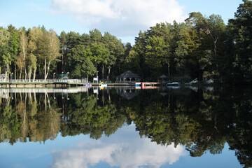 Pier and holiday resort on the lake by the forest. Beautiful reflection in the water.