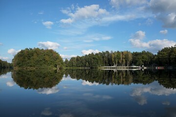 Pier and holiday resort on the lake by the forest. Beautiful reflection in the water.