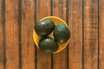 organic avocado in bowl wood background