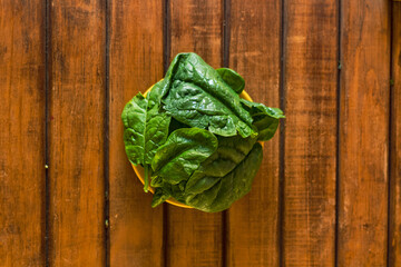 organic green spinach in bowl wood background