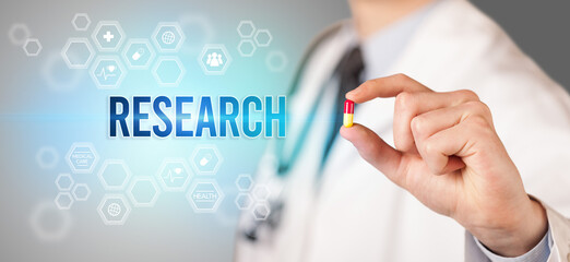 Close-up of a doctor giving you a pill with RESEARCH inscription, medical concept