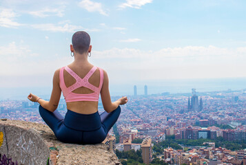 Fototapeta na wymiar Mujer haciendo yoga al aire libre con la ciudad de fondo