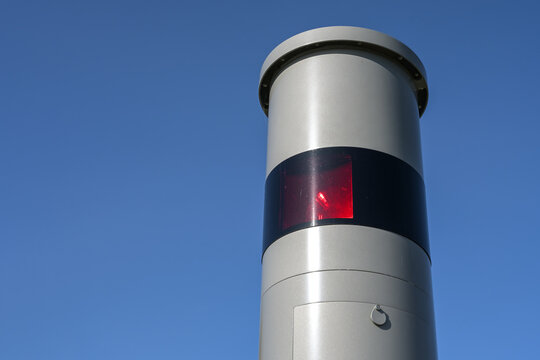 Part of a stationary speed limit enforcement with light radar, red flash and camera, traffic monitoring against dangerous speeding, blue sky, copy space