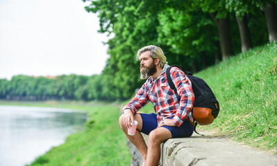 Naklejka na ściany i meble time for thinking. Man drinking hot coffee. tourist relaxing in park drink tea or coffee. Coffee on the go. man with a cup of coffee outdoors. Handsome calm bearded man outdoors with a cup