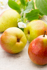 Fresh pears with leaves in a on wooden background.