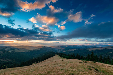 Sunset over the autumn forests in the Carpathian mountains, last sunrays painting the horizon.