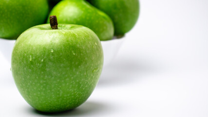 Green apple with water drops close-up.