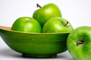 Green apples in green plate close-up.