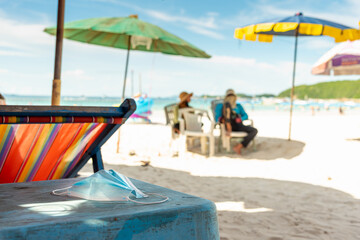 face mask was placed on the table on the beach, new normal tourism.