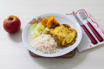 
Dish of omelet, pumpkin and cabbage, with dish neglect and with cutlery and apple for dessert. White wooden background in Brazilian kitchen copy space, top view. Food concept. Pasta concept.