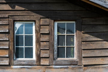 Fototapeta na wymiar Couple of old wooden windows on a wooden facade