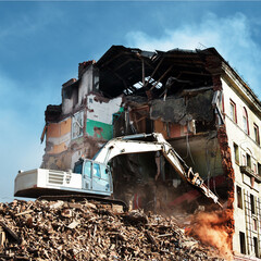 excavator demolishing a brick building. Machinery Demolishing Building