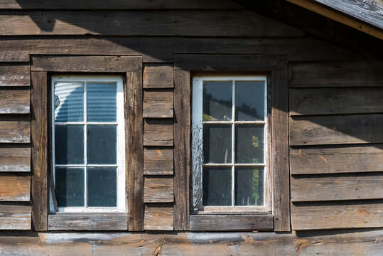 Couple of old wooden windows on a wooden facade
