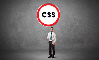 Young business person holdig traffic sign with CSS abbreviation, technology solution concept