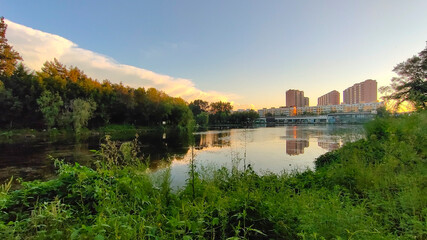 Fototapeta na wymiar A park with pond in a city. Eco-friendly living in a city.