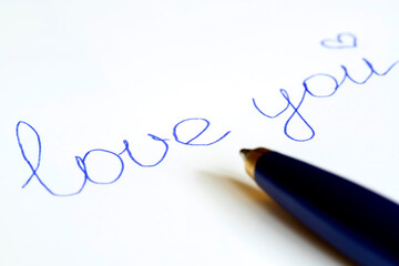 Pen blue lettering on paper love you.