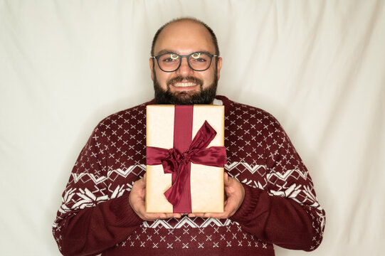 man is happy about a present and happily holds it in the camera