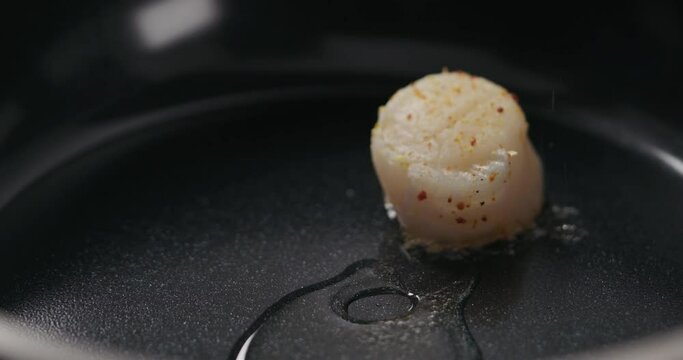 Slow motion put scallops on a ceramic pan
