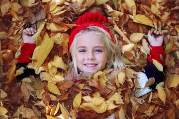 Portrait of a girl lying on the autumn lea