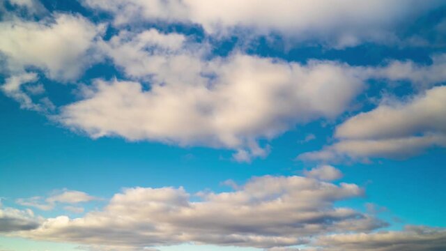 Timelapse of blue sky with floating or flying white clouds