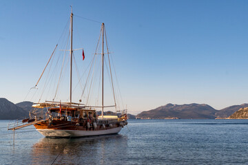 Fototapeta na wymiar A traditional Turkish gullet boat anchoring at a small bay. Blue sky and sea.