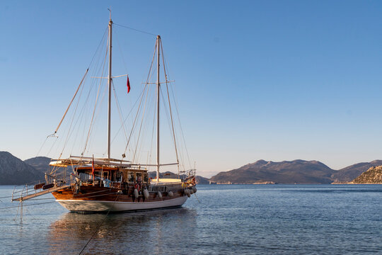 A traditional Turkish gullet boat anchoring at a small bay. Blue sky and sea.