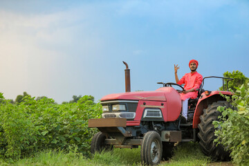Indian farmer working with tractor at field
