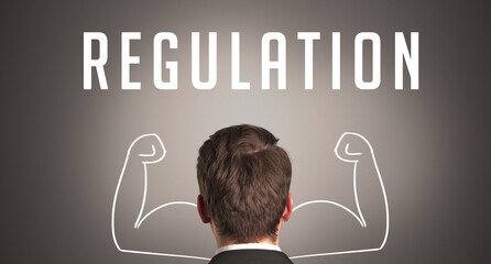 Rear view of a businessman with REGULATION inscription, powerfull business concept