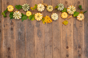 gourds and grape leaves create a border at the top of an old farm table