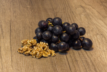 grape bunch with walnuts on a wood table