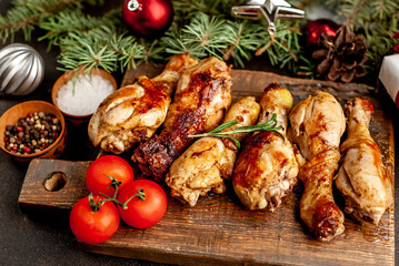 Christmas fried chicken legs on a stone background with fir and new year toys