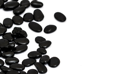 Several small black stones with a white background.