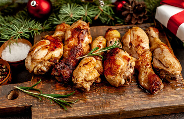 Christmas fried chicken legs on a stone background with fir and new year toys