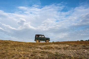 Naklejka premium suv car on top of the mountain at sunrise