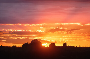 Silhouette of a Kiev city at beautiful sunset. Aerial view of buildings against colorful orange sky with sun and red clouds. Urban landscape. Background of downtown. City skyline. Cityscape