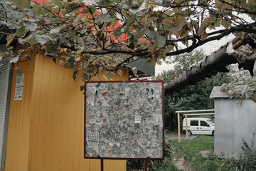 Ukrainian bulletin board on the background of a house and a car with a tree on top