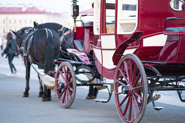 A team of horses in a horse-drawn carriage. Closed mail cart of the XIX century