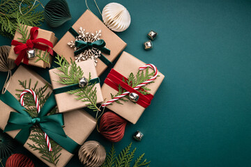 Many Christmas gift boxes tied velvet ribbons with paper decorations on turquoise background....