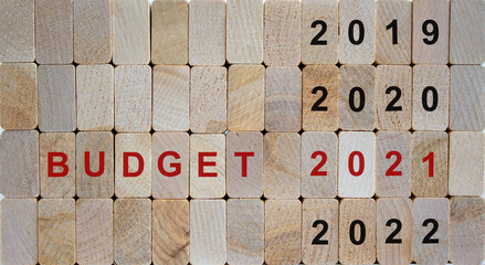 Business concept of planning 2021. Wooden cubes with the inscription 'BUDGET 2021' and numbers 2019, 2020, 2022. Beautiful wooden background, copy space.