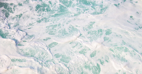 White sea foam close up. Aquamarine color of waves with foam and bubbles. Power of the ocean. Pure sea water in motion. Splash of water. Beauty in nature. Nature close up. 