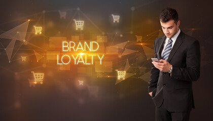 Businessman with shopping cart icons and BRAND LOYALTY inscription, online shopping concept