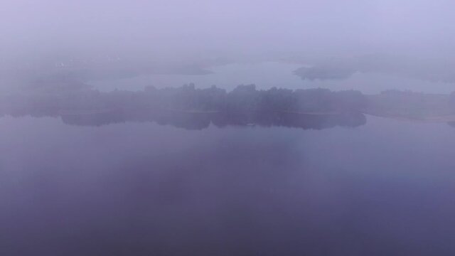 Drone flight over lake in fog, Germany