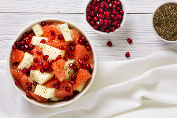 Fresh fruit salad in bowl on wooden table. Concept healthy food, diet, vegan. Flat lay, top view