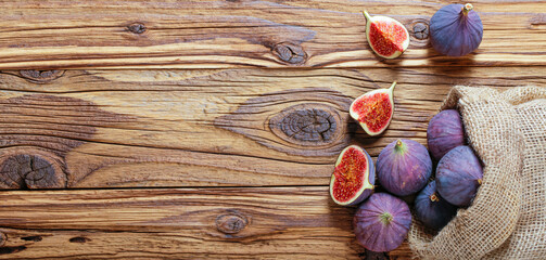 Detail of fresh figs spilled on a wooden table. Copy space for text or description.