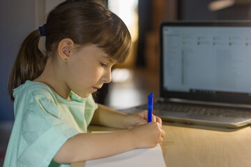 Distance online education. Little schoolgirl studies at home.