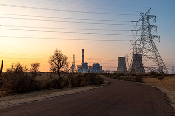 Thermal Cooling tower of nuclear power plant with blue and yellow sky