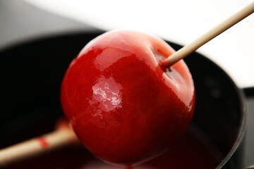 Sweet red glazed  toffee candy apples on sticks for sale on farmer market or country fair for kids.