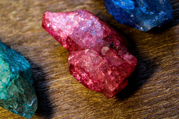 Close up of smooth red stone with blue and green stones 