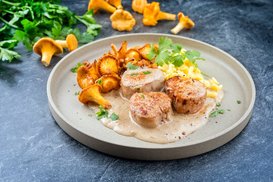 Modern Style traditionelle gegrillte Schweine Medaillon Filet in Rahmssauce mit Pfifferlinge und Sp&auml;tzle angeboten als close-up auf einem Nordic Design Teller